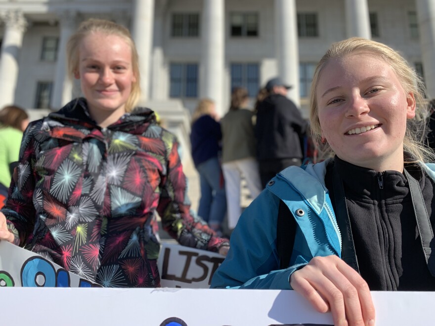 Photo of two students at a State Capitol climate action protest