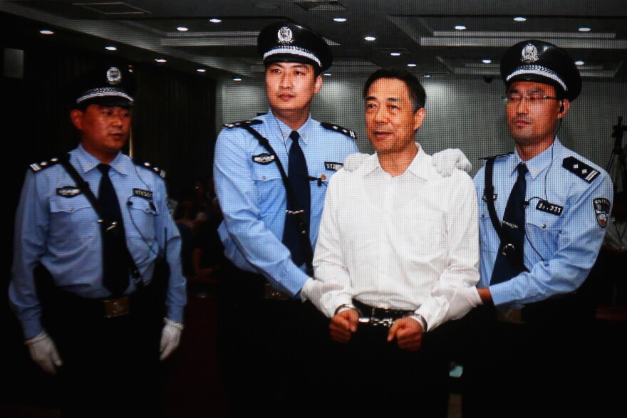 A screen shows the picture of the sentence of Chinese politician Bo Xilai (second right) on Sept. 22, 2013, in Beijing. Bo, who launched an anti-corruption campaign, embezzlement and abuse of power.