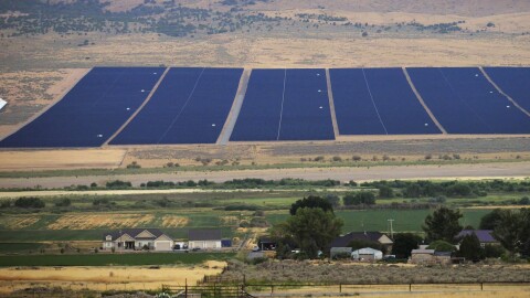A solar farm sits behind homes Tuesday, Aug. 9, 2022, in Mona, Utah. The U.S. has renewed credibility on global climate issues and will be able to inspire other nations in their own efforts, experts say, after the Democrats pushed their big economic bill through the Senate on Sunday, Aug. 7. (AP Photo/Rick Bowmer)