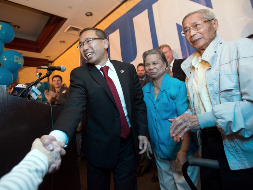 Rhode Island Republican gubernatorial nominee Allan Fung shakes hands with a supporter as his mother, Tan Ping Fung, center, and father, Kwong Wen Fung, right, look on, during a primary election night watch party Tuesday in Warwick.