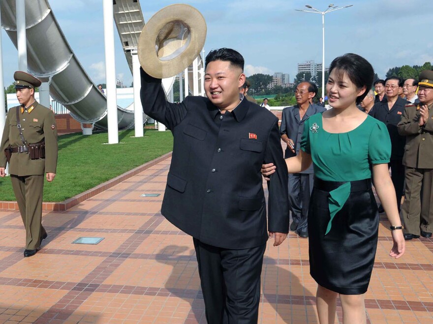 North Korean leader Kim Jong Un (center), accompanied by his wife, Ri Sol Ju, waves to the crowd as they inspect the Rungna People's Pleasure Ground in Pyongyang on July 25 in this photo released by the Korean Central News Agency. For North Koreans, it was stunning to see the first lady at the leader's side — and holding his arm.