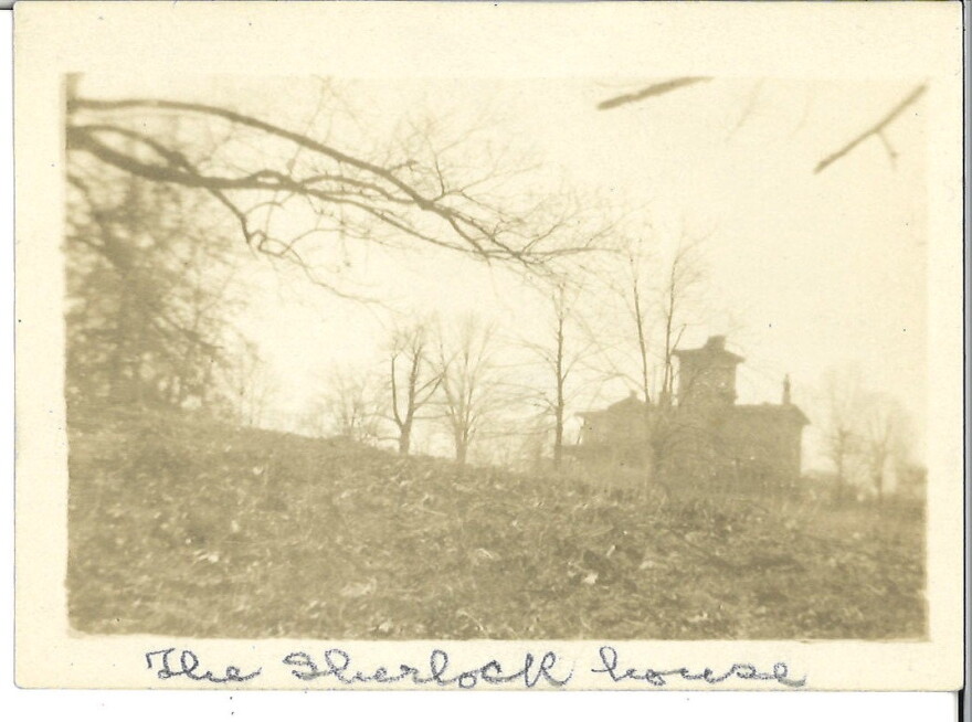 A sepia-toned photograph of a building from a distance.