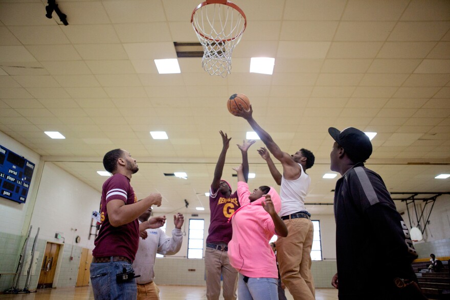 Mentor Marcus Taylor (left) plays basketball with Renaissance Academy High School students during gym class Oct. 8 in Baltimore.