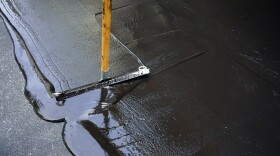 Person sealing an asphalt driveway