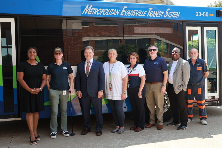 Officials, including Evansville Mayor Stephanie Terry (left), pose in front of a METS bus, July 27, 2026