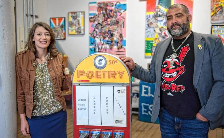 Alex Woolner and Jason Montgomery with one of their ticket dispensers converted to dispense short poems for a Poetry Vending Machine Project.