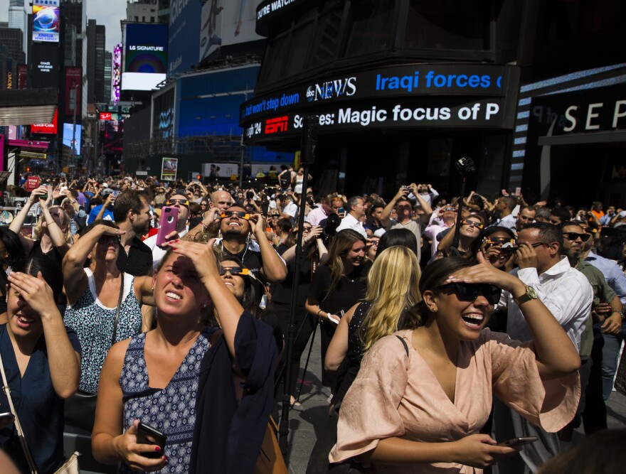 A crowd reacts as clouds move to reveal a partial solar eclipse Monday, Aug. 21, 2017, in New York. (AP Photo/Michael Noble Jr.)