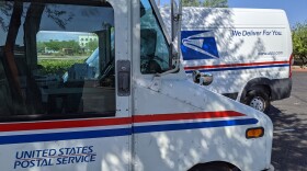 White trucks with red and blue paint say United States Postal Service