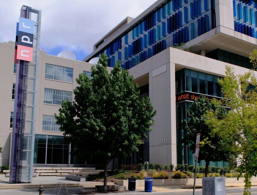 This is a picture of the NPR headquarters building in Washington, D.C. On the left side of the image is a large "NPR" sign. 