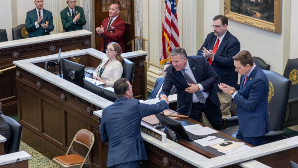 enate Pro Tem Lonnie Paxton shakes hands with Gov. Kevin Stitt on the House floor during the 2025 State of the State Address.