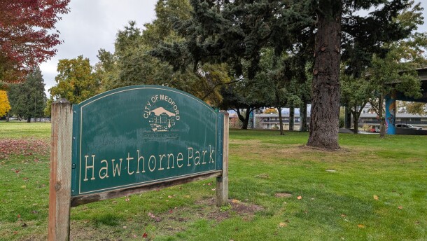 A grassy park with some trees. A sign in the foreground reads, "City of Medford, Hawthorne Park."
