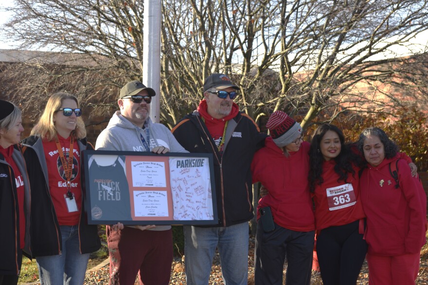 Members of Parkside Junior High School staff present a framed memento to Edder Diaz's family on Saturday, Nov. 22, 2025, near the PJHS flagpole after a Gift of Hope flag-raising ceremony, honoring Edder as an organ donor. He died Nov. 8, after a house fire earlier that week. His mother Adriana Garcia Lopez, stands right, and his sister Nicky Olivares, is second from right.