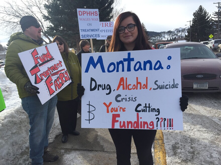 Jennifer Munger holds a sign protesting state health deparment cuts in Helena, March 1, 2018. Munger says she's recently sober and wants other people with substance abuse issues to be able to get the same treatment she had.