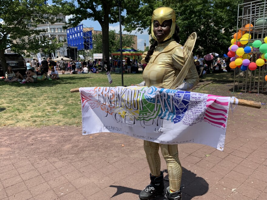 Rose Daniels displays the name of her business on Public Square during PrideFest.