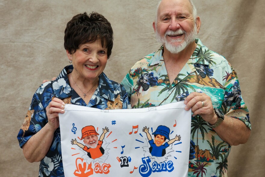 Jane Parsons, left, holds up a tote bag with her and Mac McIntosh’s duet group name.