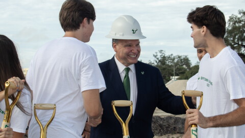 USF President Moez Limayem smiles with students at a groundbreaking ceremony for Uptown Landing. 