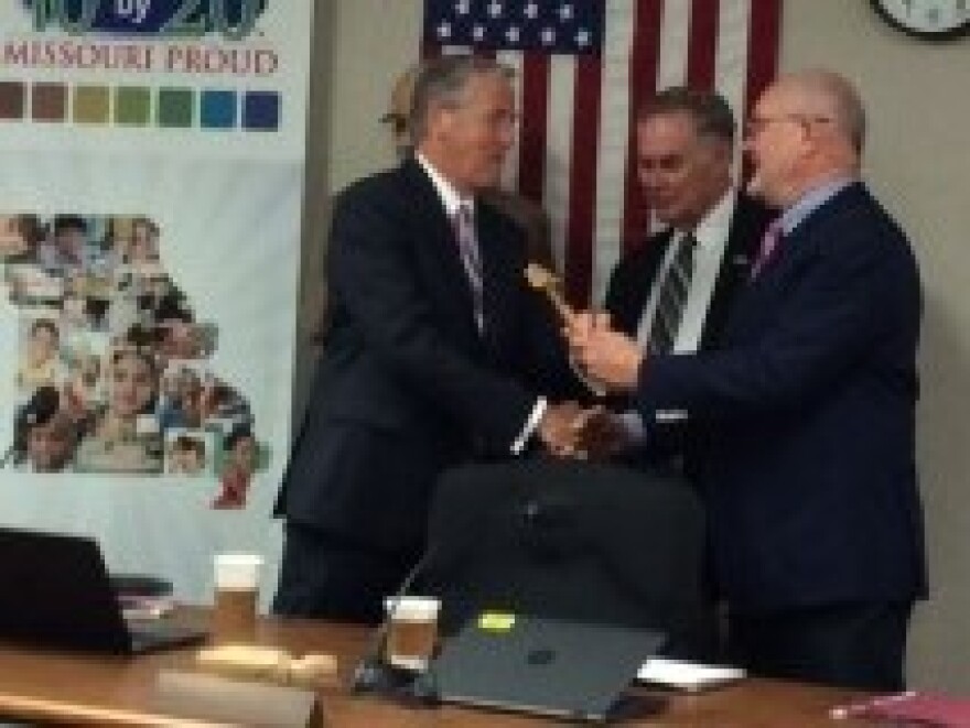 Peter Herschend, right, hands the gavel to incoming state school board President Charlie Shields. Behind them are Mike Jones (left), outgoing vice president, and incoming vice president Victor Lenz.