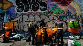 Michael Johnson takes down his tent in downtown San Francisco with the help of activists on Aug. 9, 2024.