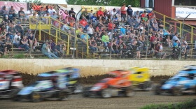 Competitors in the POWRi midget racers fly around the track in the last laps of their feature race Saturday at Valley Speedway in Grain Valley, Missouri. Fans crowded the grandstands as well as overflowed to the perimeter areas where dirt and grit from the track often pelted spectators.