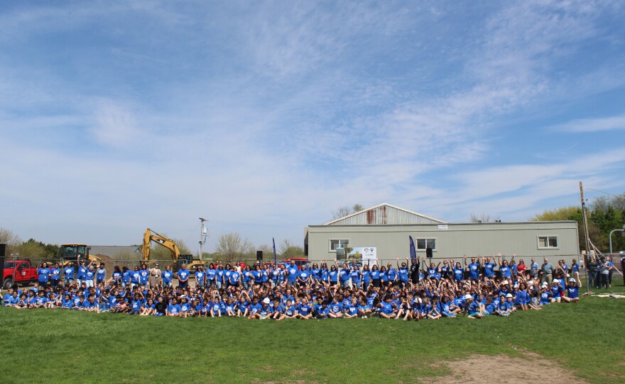 Wilder-Waite Grade School poses in front of the construction site of their new school.