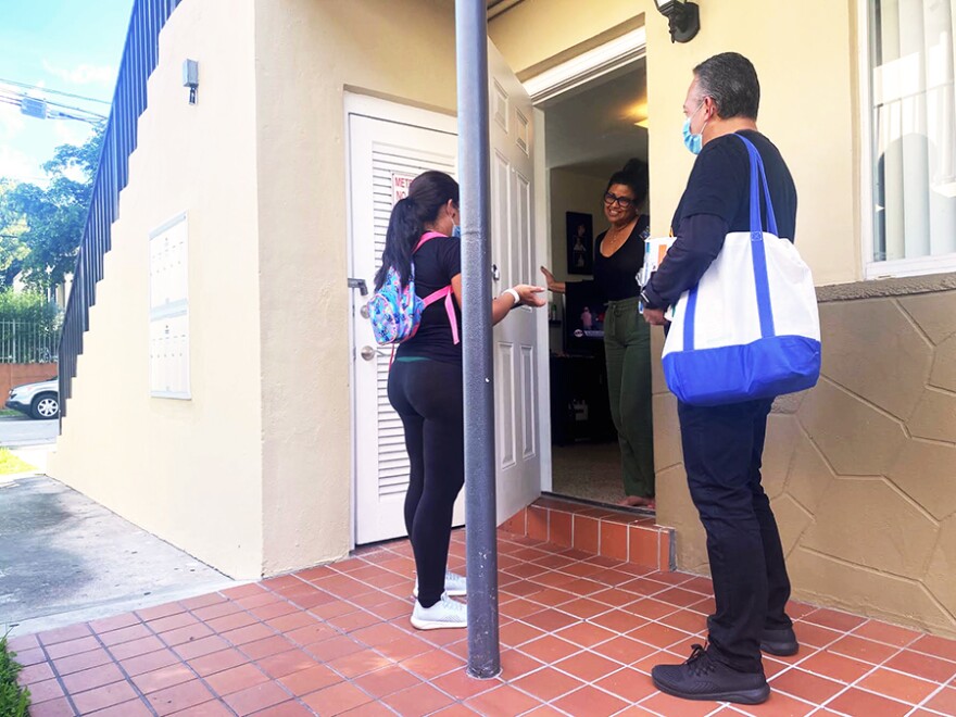 María Elena González, left, and Alejandro Días of Healthy Little Havana speak with Gloria Carvajal about getting tested for COVID-19 on Oct. 23, 2020.