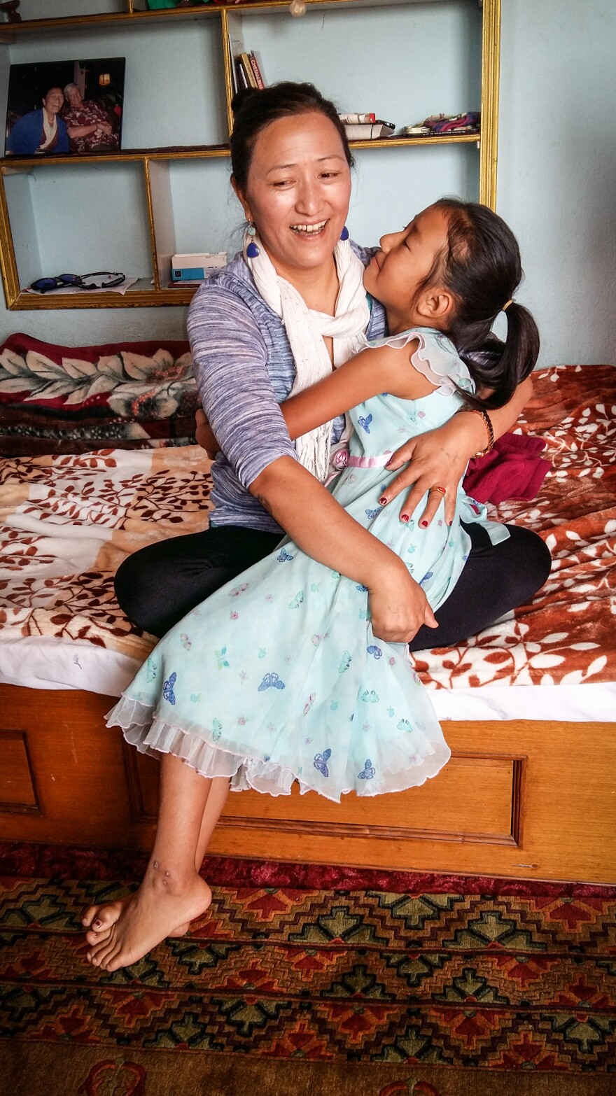 Chheten Drolma and her niece embrace. Drolma's sister — the little girl's mother — died in the disaster. Drolma is now in the process of adopting her late sister's three daughters.