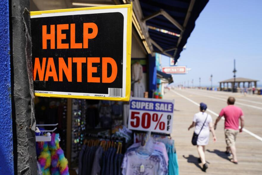People walk past a help wanted sign in front of a souvenir shop along the boardwalk, in Ocean City, New Jersey. (Matt Slocum/AP)
