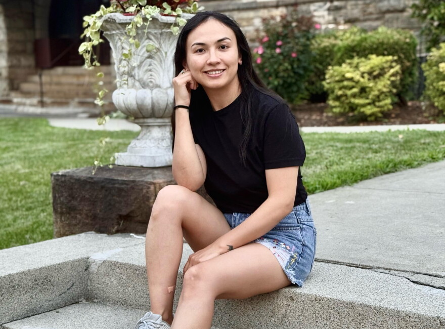 A woman in jean shorts sits on steps