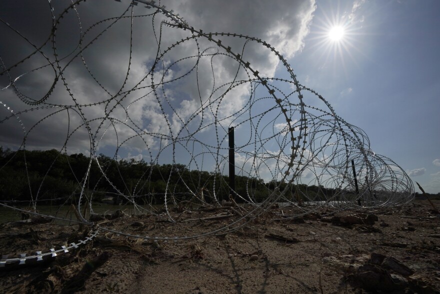 Concertina wire lines the banks of the Rio Grande on the Pecan farm of Hugo and Magali Urbina, near Eagle Pass, Texas, Monday, July 7, 2023. A dispute over razor wire that Texas installed on the U.S.-Mexico border to deter migrants continued Thursday, Nov. 30, 2023, after a judge allowed Border Patrol agents to continue cutting the barrier but also laid into the Biden administration over immigration enforcement.