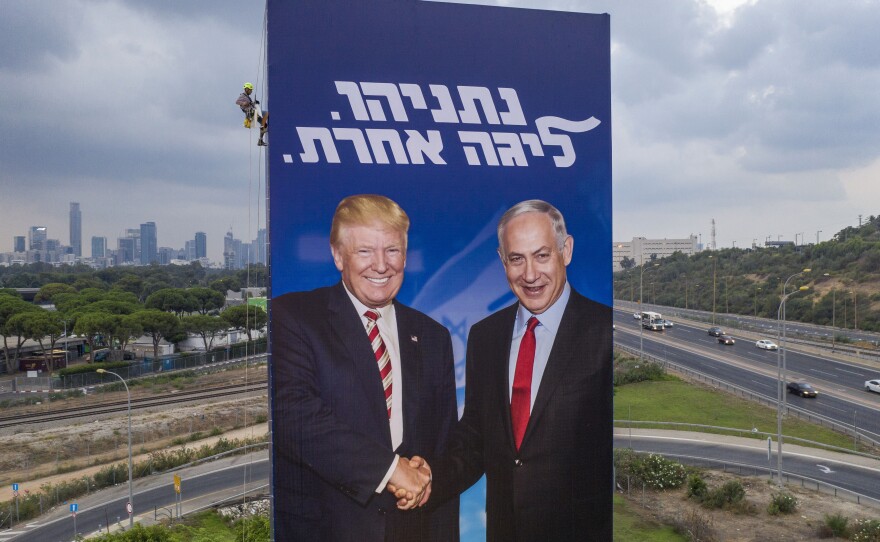 A worker hangs a Likud party campaign billboard of Netanyahu and President Trump in Tel Aviv, Israel, on Sept. 8. The Hebrew message on the billboard reads "Netanyahu, in another league."