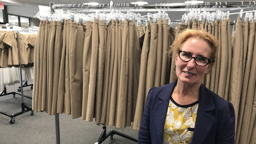 Photo by Paul Bibeau. Brianna Plummer, a clothing designer working for the Navy, stands in front of hundreds of prototypes used to gather data in an attempt to make better-fitting uniforms for women in the Navy.