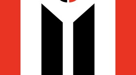 The Arapaho Flag, with two long red stripes on the edges and two long black stripes in the middle of the flag. At the top of the flag is a white triangle with a small red and black circle inside it.