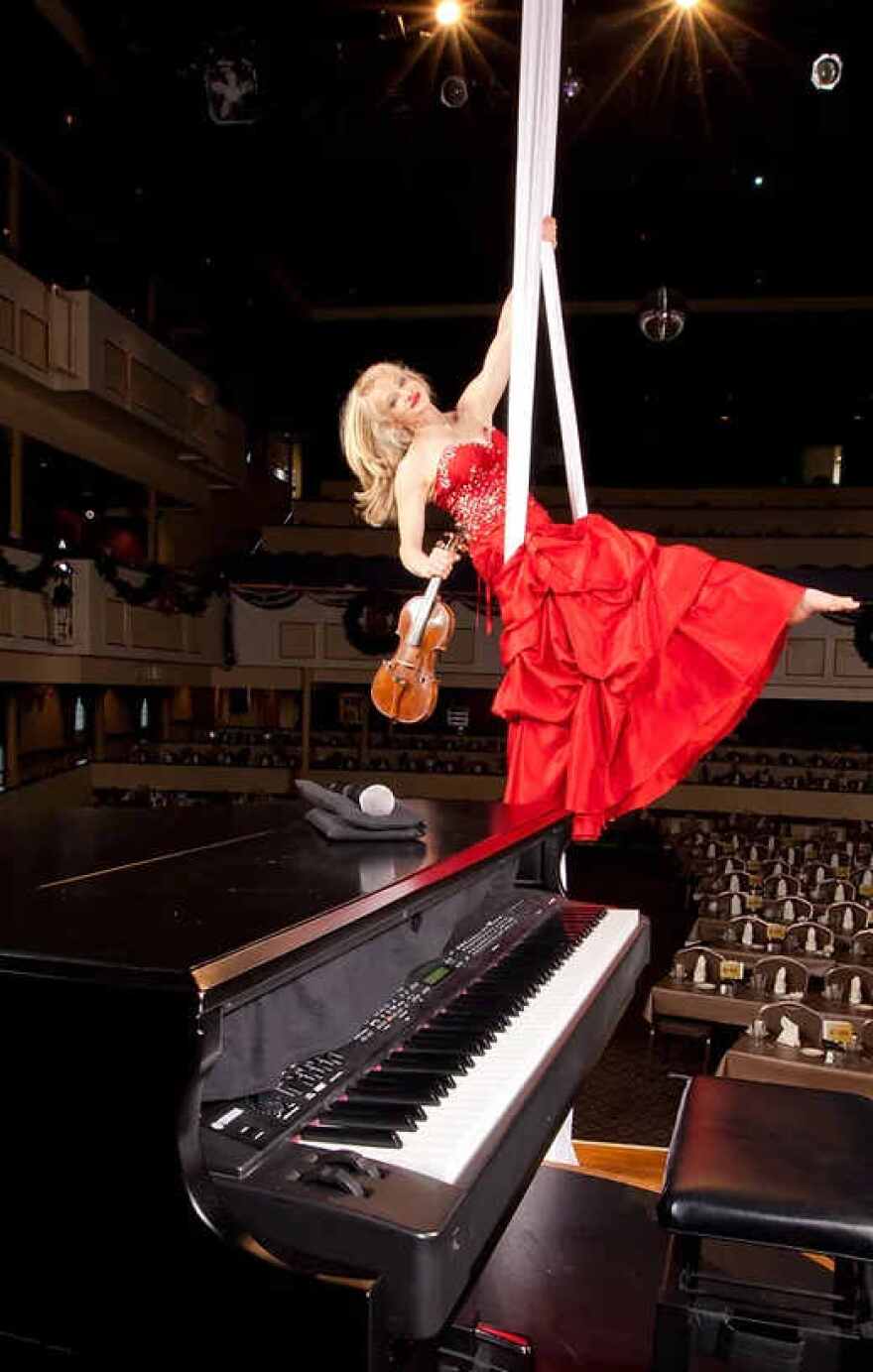 Aerial violinist Janice Martin will soar above the symphony and chorus while playing the violin.