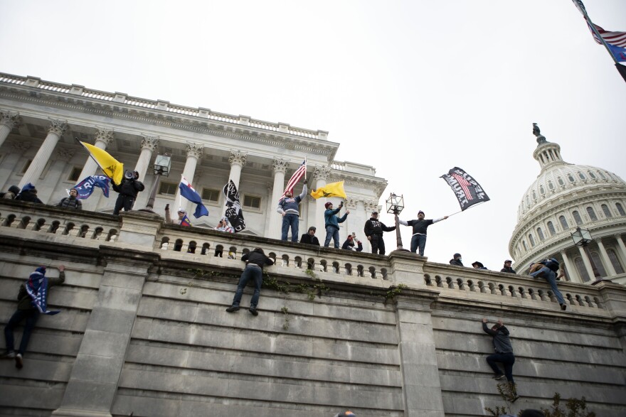 Supporters of President Donald Trump climb the west wall of the Capitol in Washington on Jan. 6, 2021.