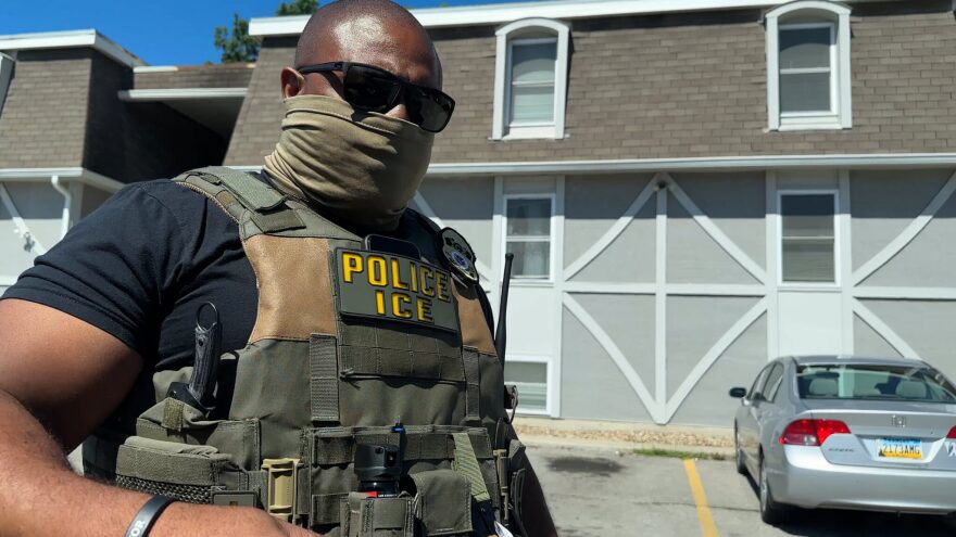 An ICE officer orders Shana Leacox to move back, after officers blocked her with their cars on Saturday morning in Olathe.