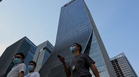 People walk in front of the Evergrande headquarters in Shenzhen, China's southern Guangdong province on September 15, 2021. (Noel Celis /Getty Images)