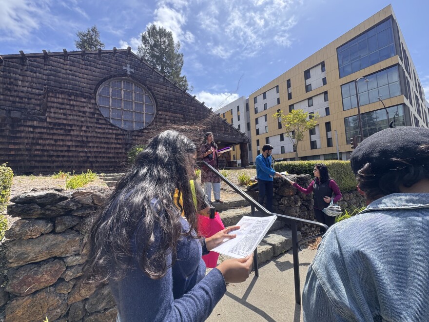 An Indian Woman stands on the UC Berkeley campus reading text written by Kartar Singh Sarabha