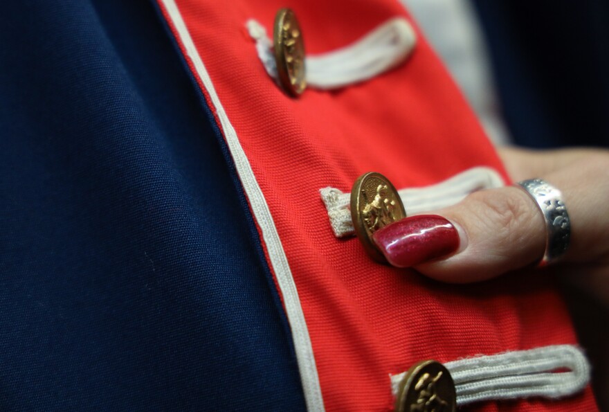 Terry Sinopoli, marketing and customer service manager at Arlene’s Costumes, shows off handmade costume adorned with original Rochester Button Factory buttons on Thursday, October 23, 2025.