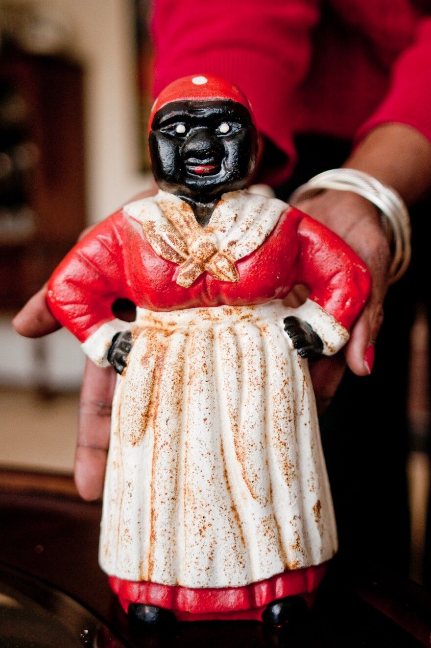 Dora Robinson holds the cast-iron figure of Aunt Jemima, originally used as a doorstop, which she found at a yard sale in upstate New York.