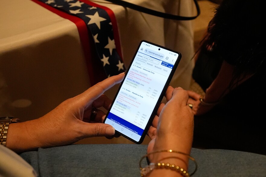 A supporter follows election voting results during an election night watch party for Sen. Bill Cassidy, R-La., Saturday, May 16, 2026, in Baton Rouge, La.