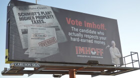 A billboard shown on Thursday, Oct. 8, 2026 stands on the northbound side off Business 97 in Bend, Ore. It depicts a fake newspaper and headlines alongside a real image of Deschutes County Commissioner candidate Rob Imhoff. The billboard discloses using AI.
