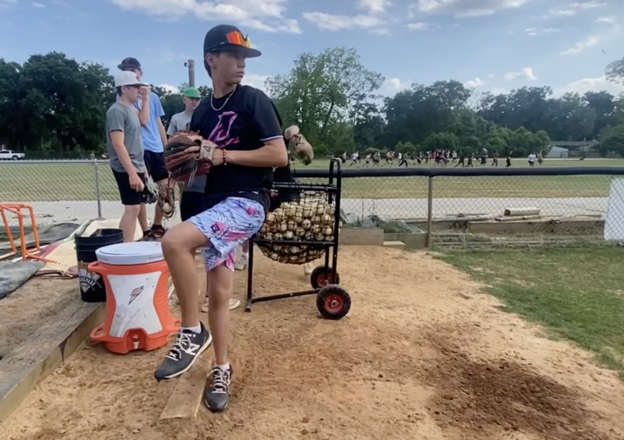 Trenton eighth grader Logan Marlo pitches in a practice bullpen alongside the entire Tigers pitching staff. Chris Marlo encourages his young arms to avoid throwing with max effort on back-to-back days, especially if they pitched in a game the day prior. (Ethan Eibe/WUFT News)