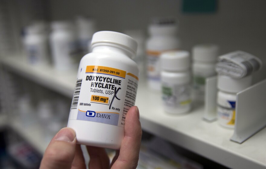 A pharmacist holds a bottle of the antibiotic doxycycline hyclate. The CDC has released data that show how chlamydia, gonorrhea and syphilis infections have been accelerating across the country. The agency is considering recommending doxycycline to be used after sex to prevent those infections.