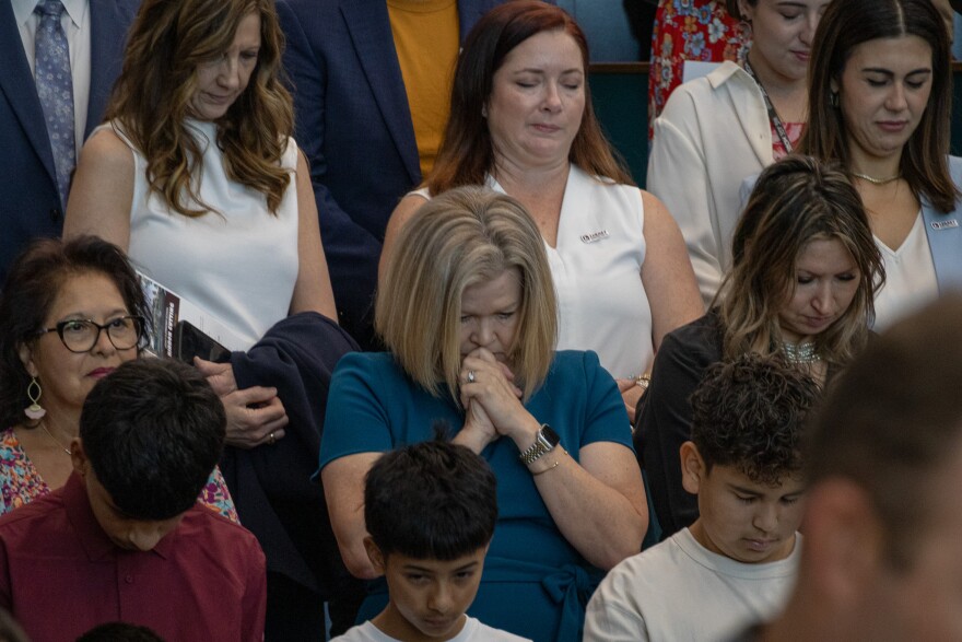 Attendees of the ribbon cutting event at Legacy Elementary take a moment to pray Oct. 10, 2025.