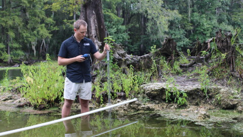 Environmental scientist Bill Hawthorne measures water velocity in the Poe Spring run.