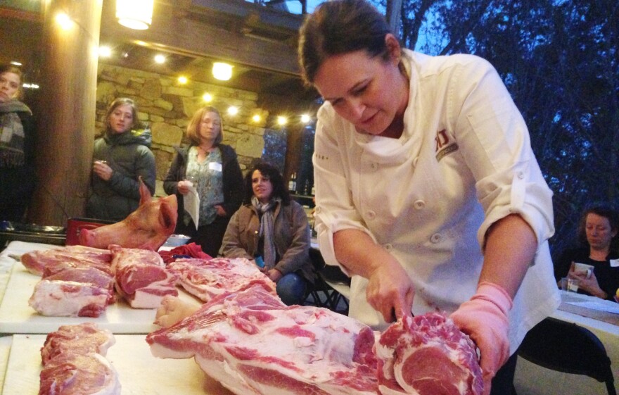 Master butcher Kari Underly cuts into a hog during a "Women in the Meat Business" workshop in Chapel Hill, NC.