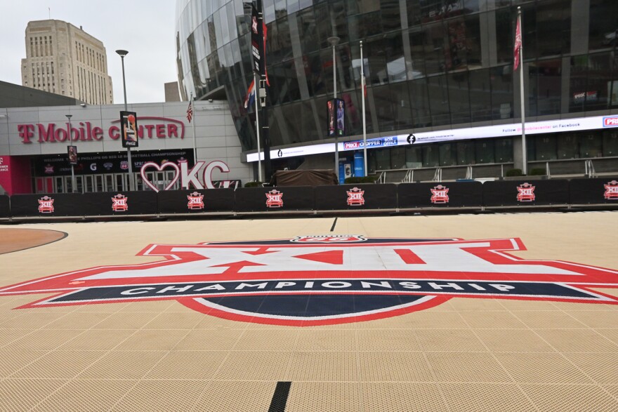 An outdoor basketball court shows an "XII Championship" logo on the floor. Behind it is a large, shiny oval building with the sign "T-Mobile Center" on it.