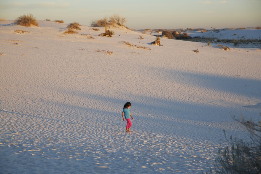 A girl plays in the sand during the evening sunset stroll.