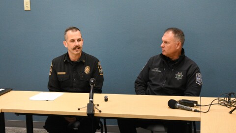 Eugene-Springfield Fire Chief Mike Caven (left) and Eugene Police Chief Chris Skinner (right) seated at a table.