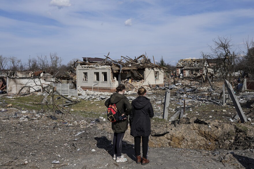 Women look at houses damaged by shelling in Chernihiv, Ukraine, Thursday, April 7, 2022. Ukraine is telling residents of its industrial heartland to leave while they still can after Russian forces withdrew from the shattered outskirts of Kyiv to regroup for an offensive in the country's east. (Evgeniy Maloletka/AP)